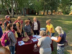 people gathered around an outdoor information table
