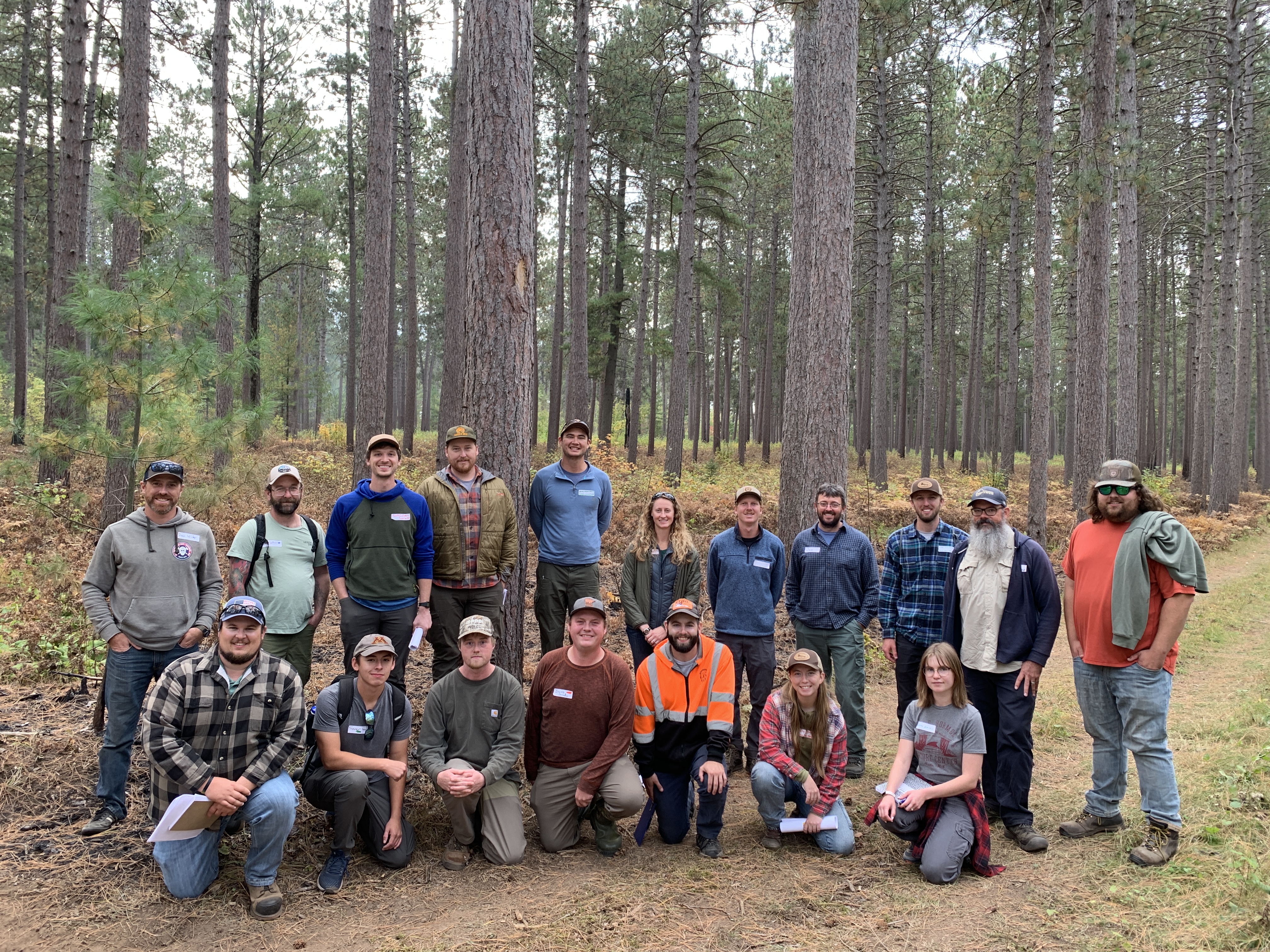 several people posing for picture in the woods