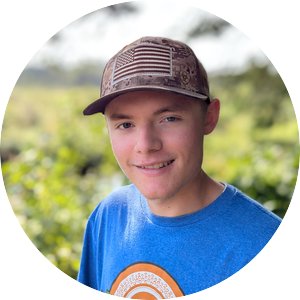 man in field wearing a ball cap