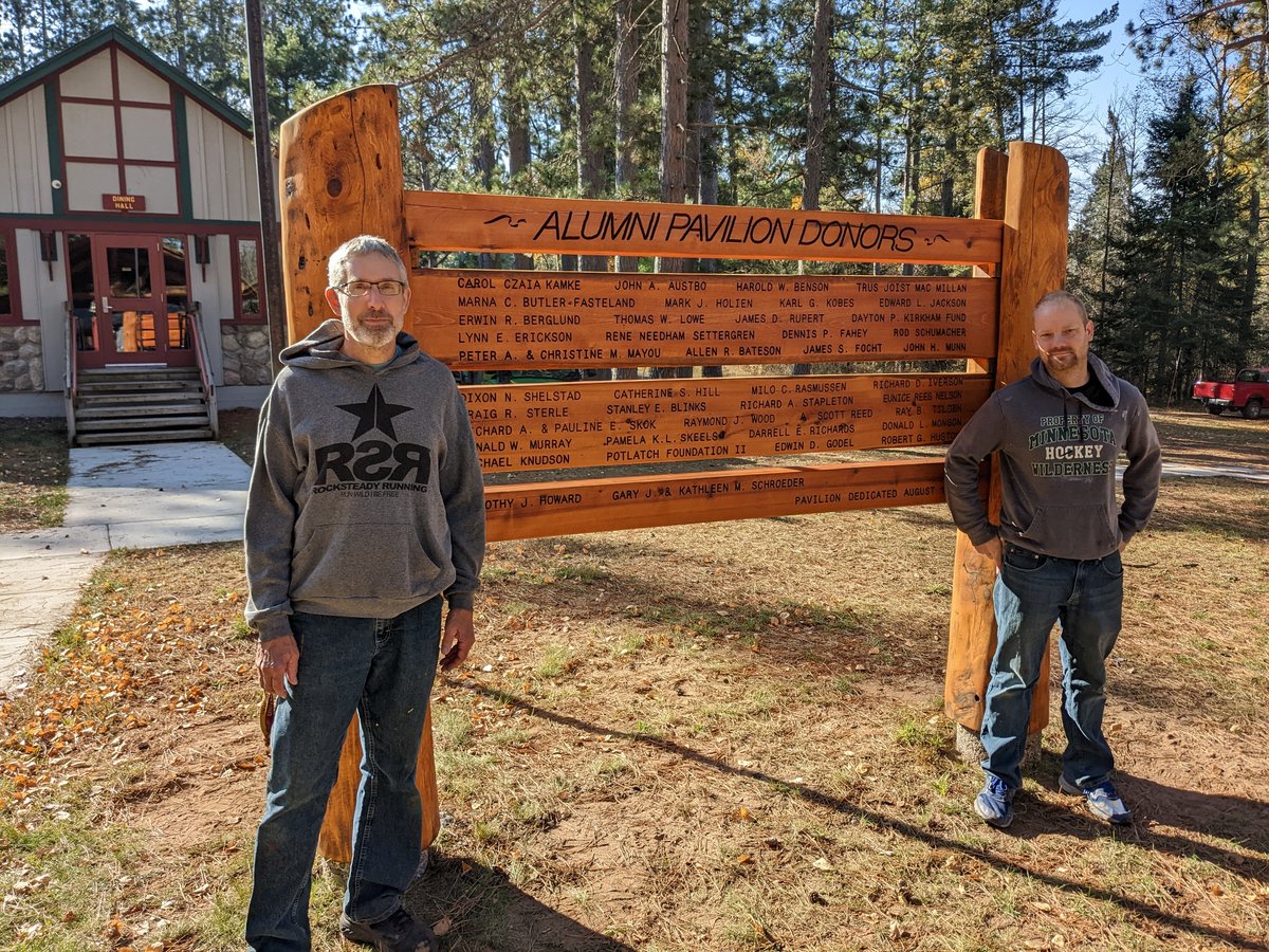 Mark Hagen and Chad Korby show off the Alumni Pavilion sign they refinished Autumn 2022. 